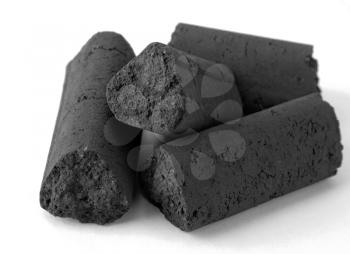 Bits of formed black coal on a white background