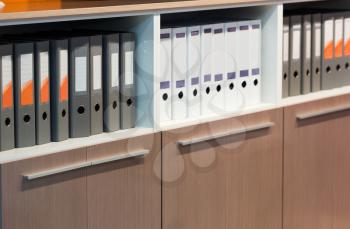 Folders with documents stand in the row in the office