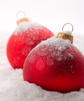 Red christmas baubles on snow