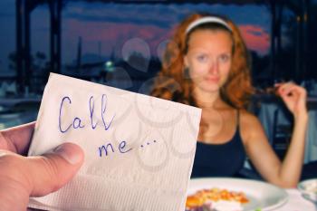 Call me... message on napkin in hand against pretty girl