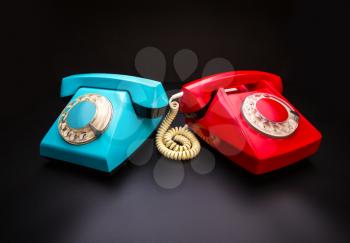 Vintage red and blue telephones side by side