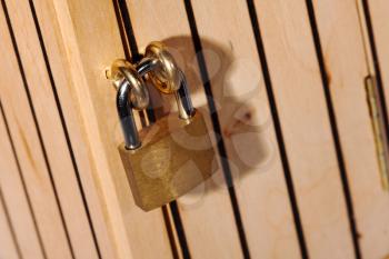 Small antique locked padlock on wooden door