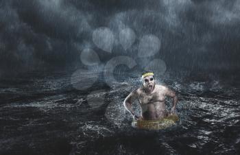 Man in the sea with lifebuoy while storming