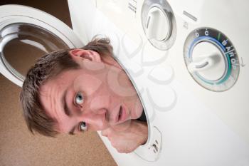 Close-up of surprised man inside washing machine