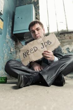 Homeless businessman holding sign asking for new job