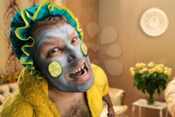 Strange, crazy man with face pack in home interior