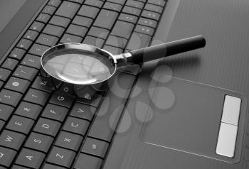 Magnifying glass on laptop computer keyboard
