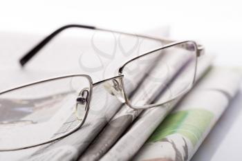 Macro of glasses lieing on the newspapers