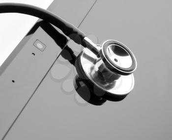 Medical stethoscope on laptop display. In B/W. Isolated
