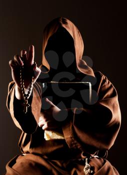 Portrait of mystery preaching monk with wooden rosary and bible