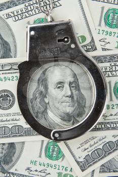 Close-up of handcuffs on one hundred banknotes