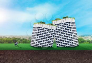 Businessman looking at two falled buildings standing on the grass