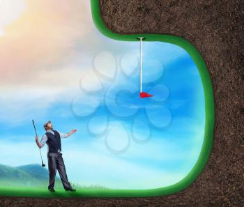 Businessman playing strange golf in open air