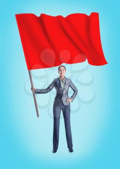 Woman holding a red flag stands isolated on blue background