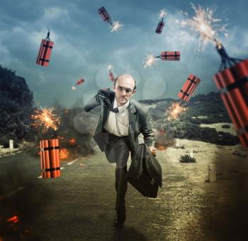 Businessman running from dynamite exploding on the road