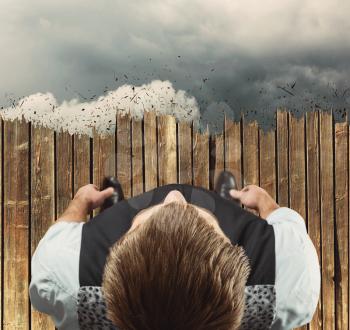Up view of the man standing on the edge of wooden floor in clouds