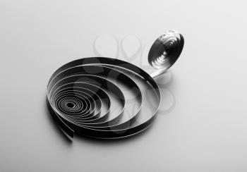 Two metallic spirals on grey background