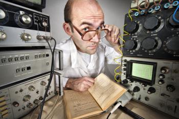 Pensive scientist reading book at vintage technological laboratory