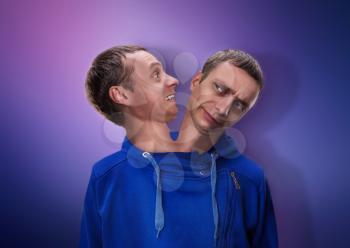Concept of split personality, a man with two heads over blue background