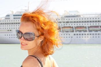 Beautiful smiling woman and cruise ship on background