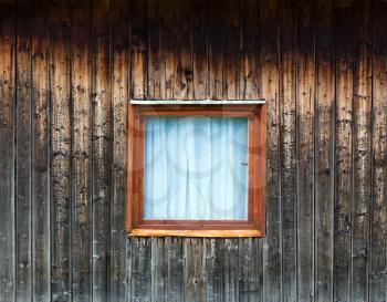 Old window on weathered wooden house