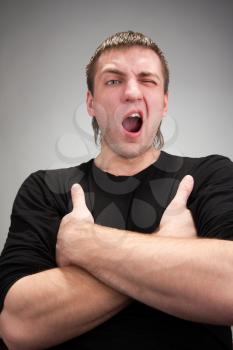Portrait of yawning man with crossed hands