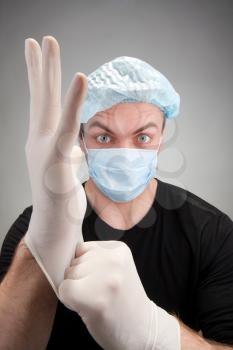 Portrait of surprised dark surgeon wearing gloves