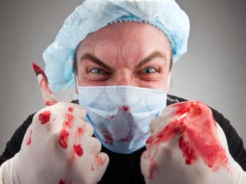 Mad mental sick blood soiled surgeon with knife