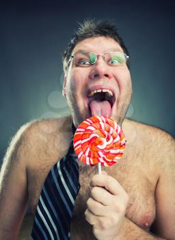Crazy shirtless man licking lollipop