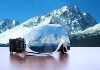 White ski glasses against winter mountains