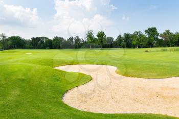Golf field with sand zone in summer day