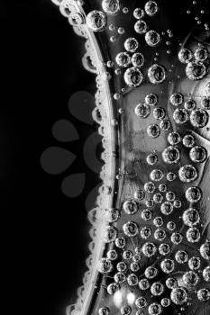 Silver surface with bubbles under water. In B/W