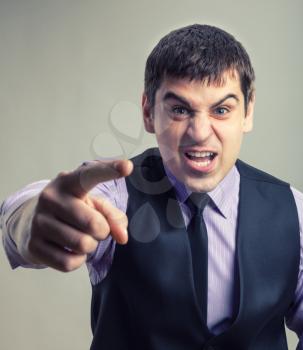 Angry businessman pointing at you. Toned colors