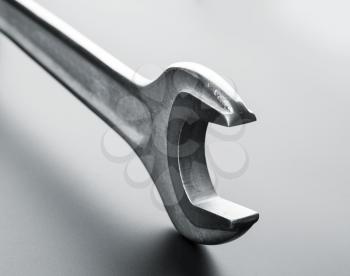 Stainless steel wrench on grey background