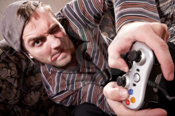 Excited man with joystick playing video games at home