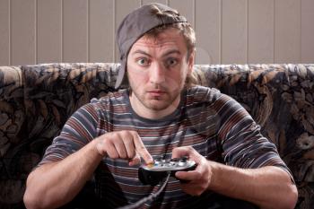 Surprised man with joystick playing video games at home