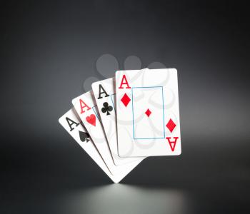 Four aces standing on dark background
