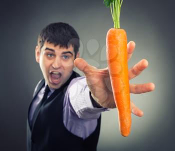 Man trying to reach fresh carrot