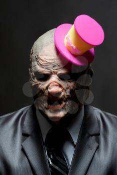 Sad monster in business suit with funny pink hat