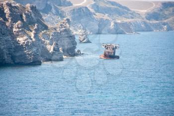 Shipwreck. Rusty cargo ship near mountain coast