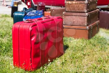 A lot of old suitcases stand on the grass