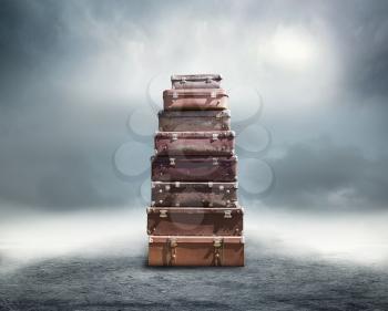 Stack of old brown suitcases over abstract background