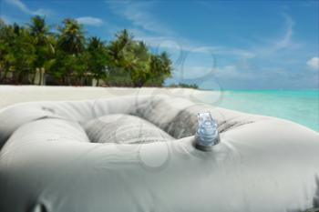 Inflatable bath cushion with closed valve isolated on the beach
