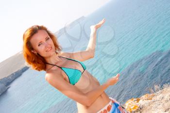 Attractive woman in bikini inviting to sea