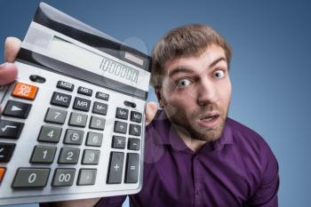 Surprised man holds calculator with a big total