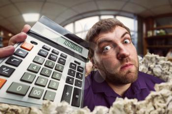 Surprised accountant holds calculator with a big total