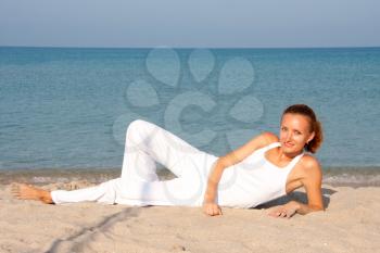 Tan smiling woman resting on the beach