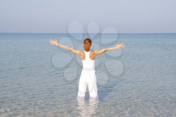Woman in sea with raised arms