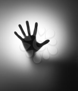A hand behind matted glass. In B/W