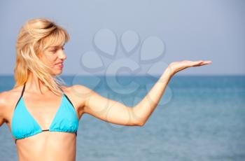 Attractive woman in bikini presenting the sea vacation